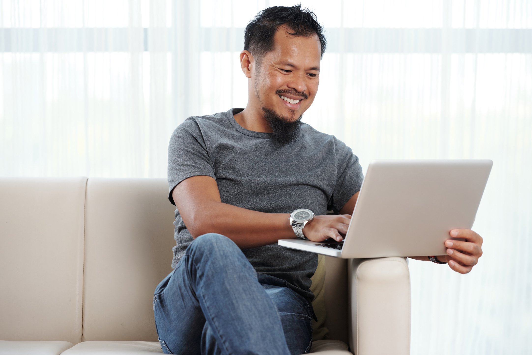 Filipino Man Using Laptop at Home